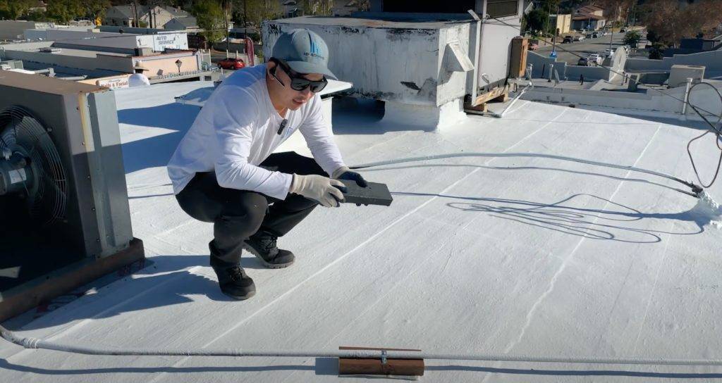 A professional contractor working on the roof of a commercial building in Los Angeles.