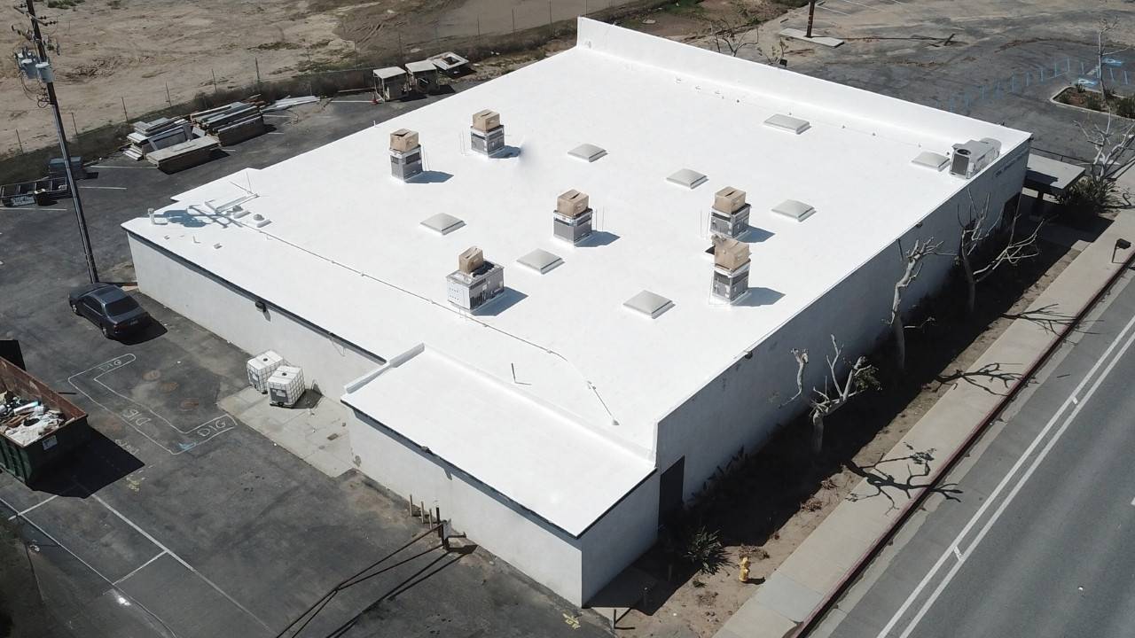 An aerial view of a white building with roof vents.