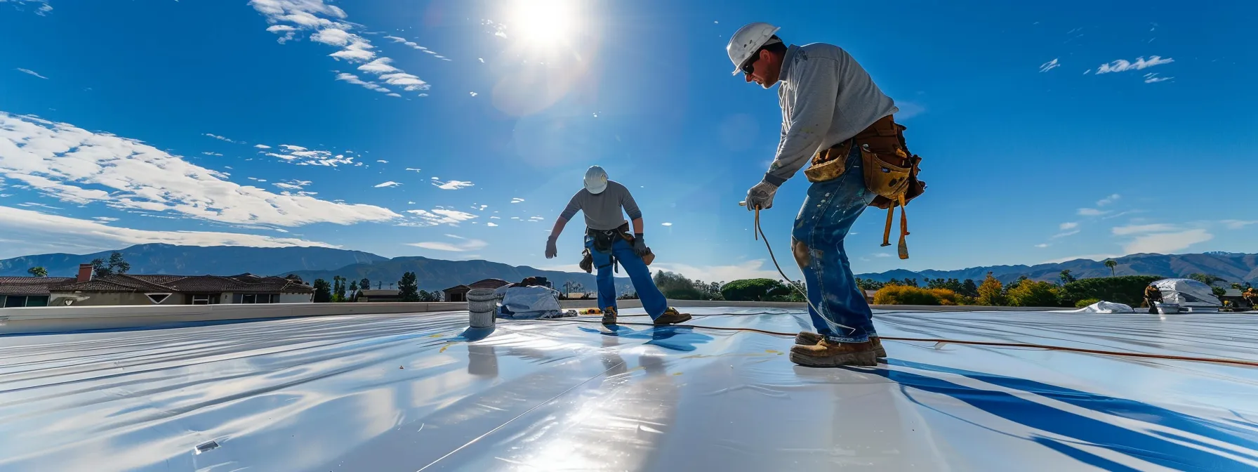 a team of professional roofers carefully installing reflective coatings on a commercial roof under the sunny skies of los angeles.