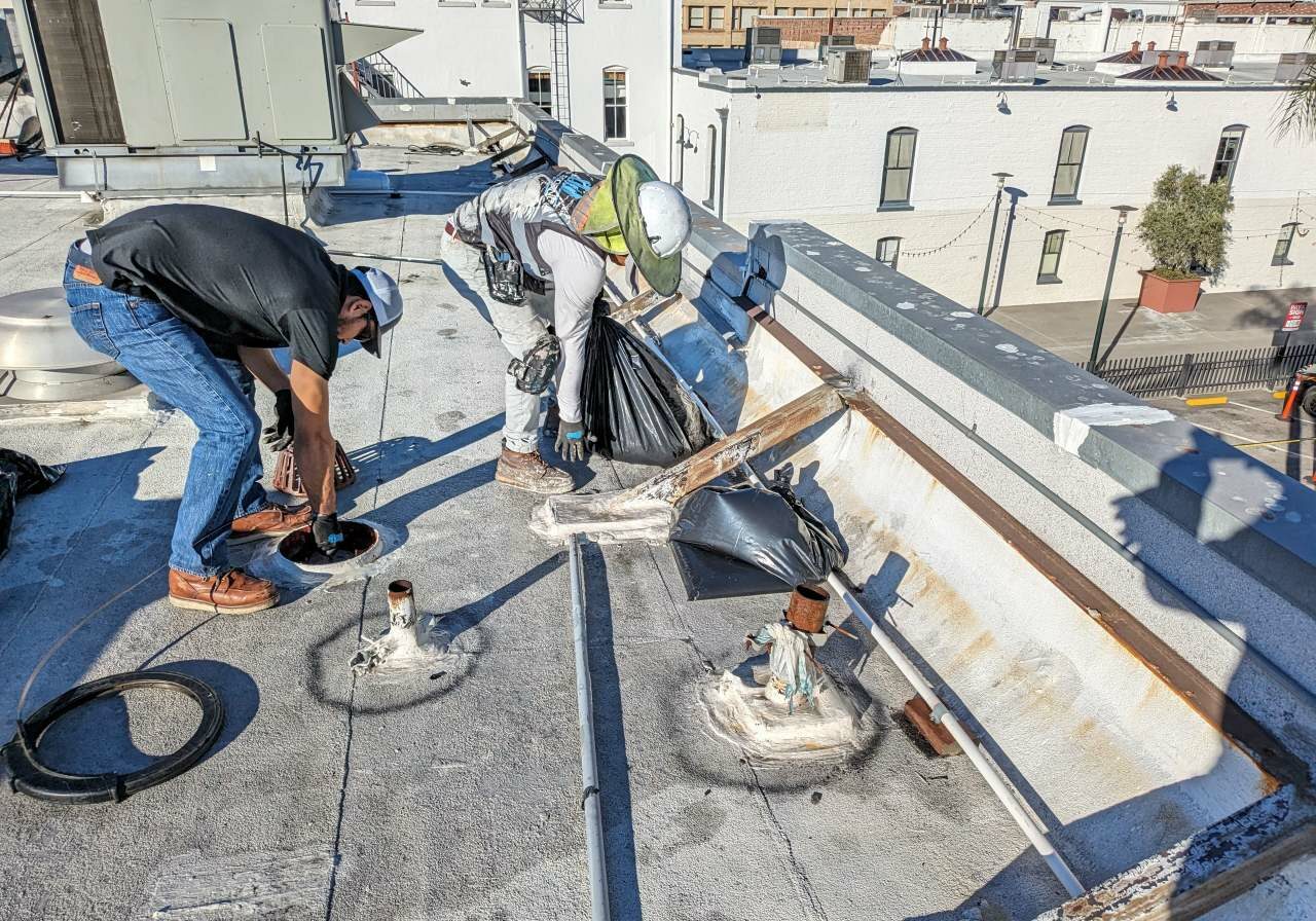 Two men working on the roof of a building.